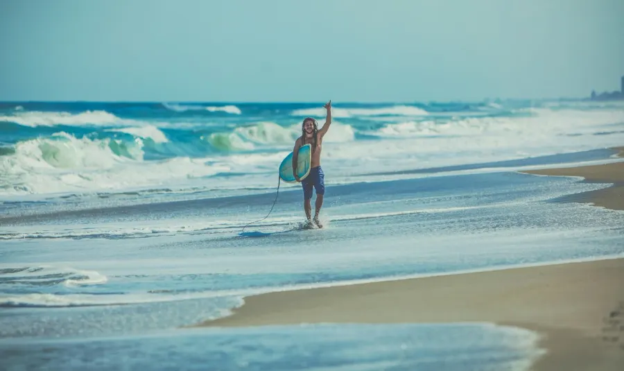 Surfer walking toward the ocean